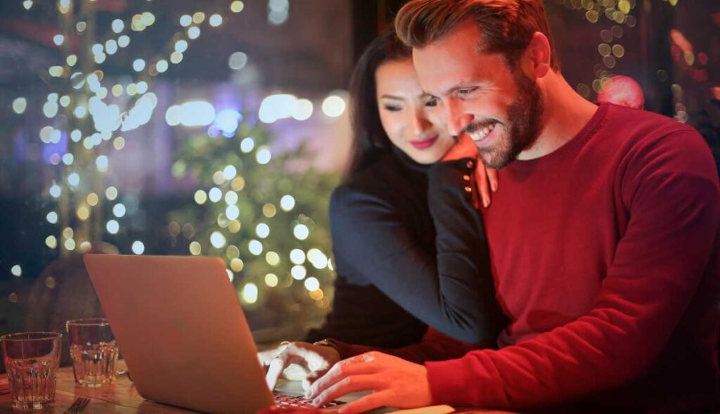 Casal feliz a olhar para portátil, simbolizando os resultados positivos da formação-ação numa PME